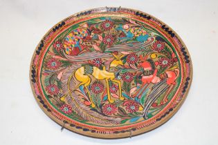 An early 20th century Eastern European glazed metal circular platter with animal and floral