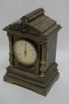 An old ornate brass clock case with raised figure and columns,