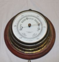 An old aneroid circular barometer by John Barker & Co,