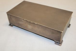 A silver rectangular cigarette box with engine turned hinged lid on shaped feet,