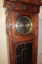 A 1930's/40's oak long case clock with silvered dial in carved oak rectangular case