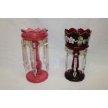 A cranberry tinted glass table lustre with lozenge droplet decoration,