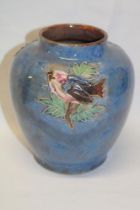 A Royal Doulton pottery tapered vase with bird and leaf decoration on blue ground,