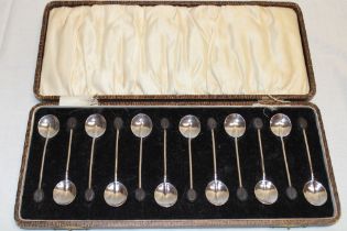 A set of twelve silver Art Deco-style coffee spoons with bean terminals,