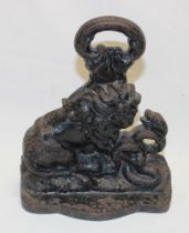 A Victorian cast-iron door stop in the form of a lion with a serpent,