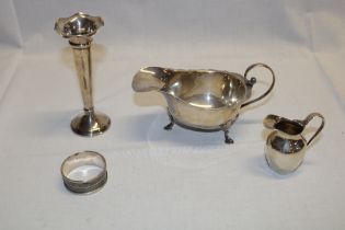 A silver classical shaped sauce boat with scroll handle and hoof feet,
