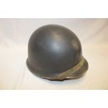 An American M1 steel combat helmet with liner and chin strap