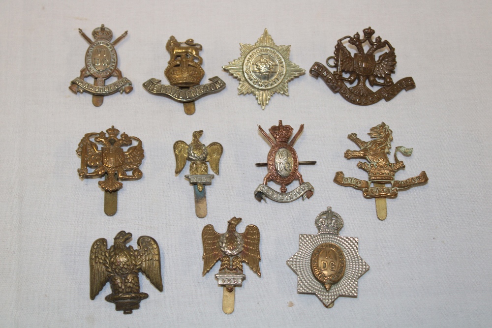 Eleven various Dragoons and Dragoon Guards military cap badges including 1st King's Dragoon Guards,