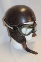 A vintage motorcycle racing helmet by Cromwell together with a pair of motorcycle goggles