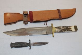 A large Bowie-style knife with 10" steel blade and antler hilt in leather sheath and one other