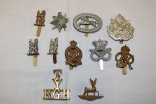 Various military cap badges including Northamptonshire Yeomanry, brass shoulder title "T/Y/R.G.H".