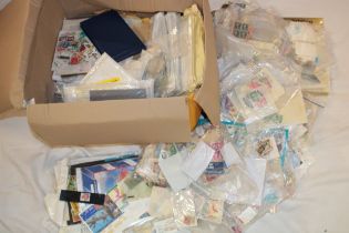 A box containing various packets of mixed World stamps