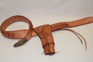 A good quality leather Western-style gun belt with holster and brass oval buckle