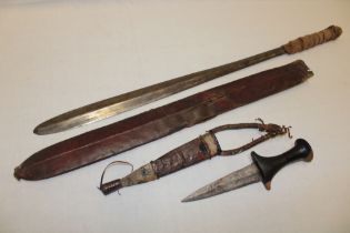 An African tribal dagger with double-edged steel blade and wood hilt in leather and snakeskin