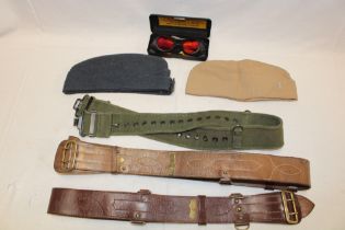 Two Sam Browne leather belts with brass mounts, a pair of NATO laser goggles,