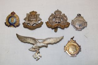 A Second War German Luftwaffe winged eagle badge with pin backing, Suffolk Regiment cap badge,