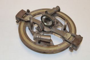 A small brass navigational sextant with silvered calibrated dial,