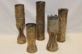 Five various First War trench art shell case vases engraved and decorated in relief with varying