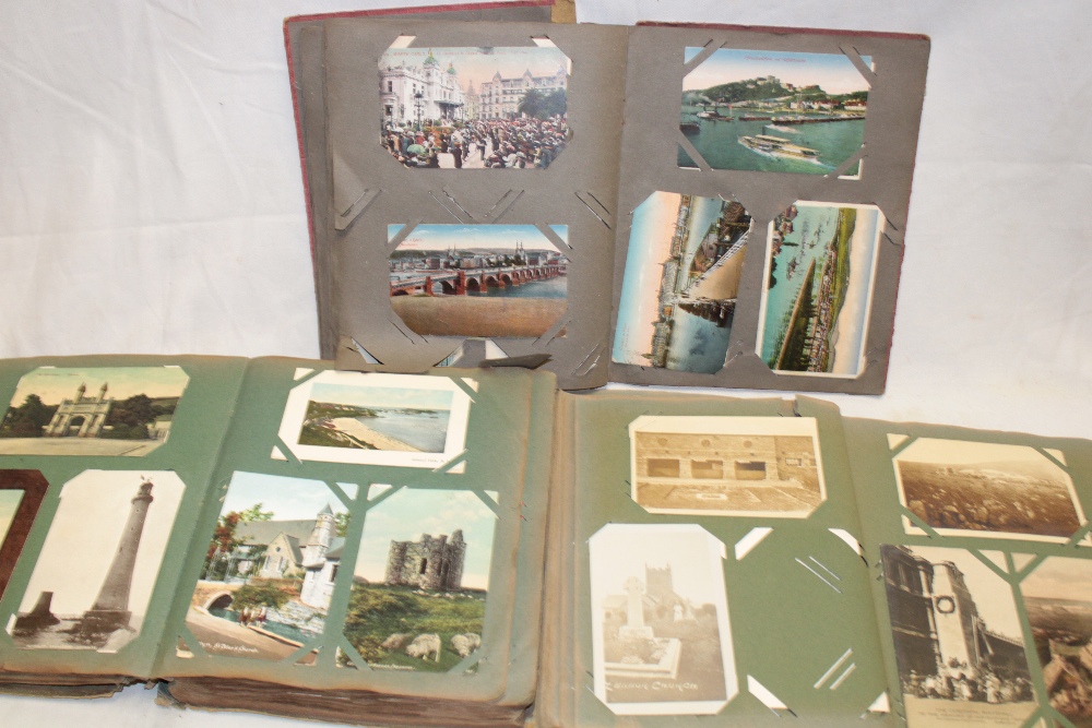 Three albums containing a selection of mixed black and white and coloured postcards including some