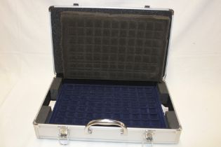 An aluminium coin collectors case with fitted interior