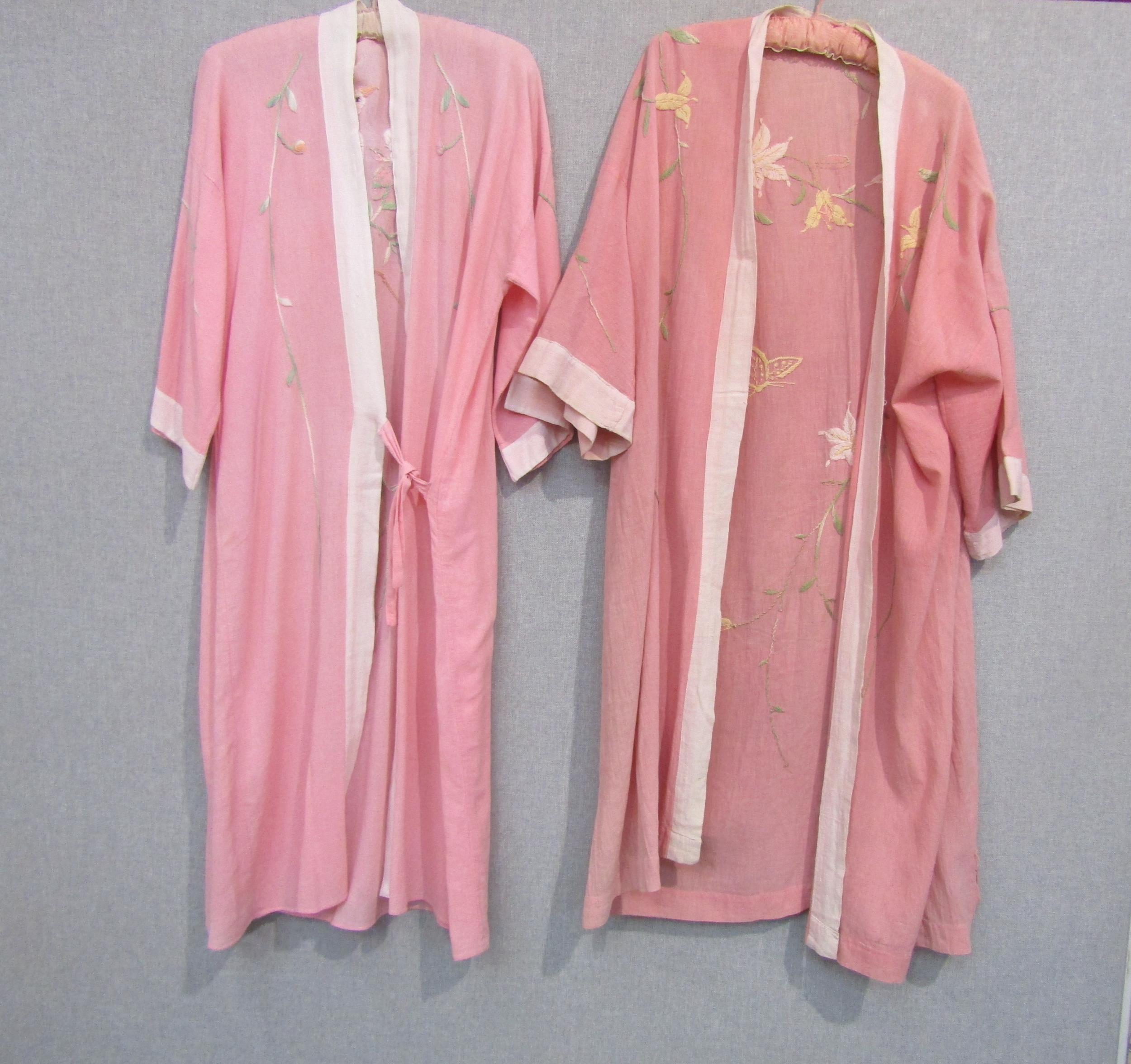 Two early 20th Century kimono style dressing gowns in pink, with hand embroidered floral detail