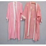 Two early 20th Century kimono style dressing gowns in pink, with hand embroidered floral detail