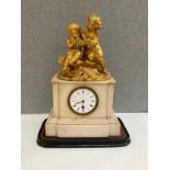 A 19th Century French alabaster mantel clock, gilded figural top, cracked to reverse, glass missing,