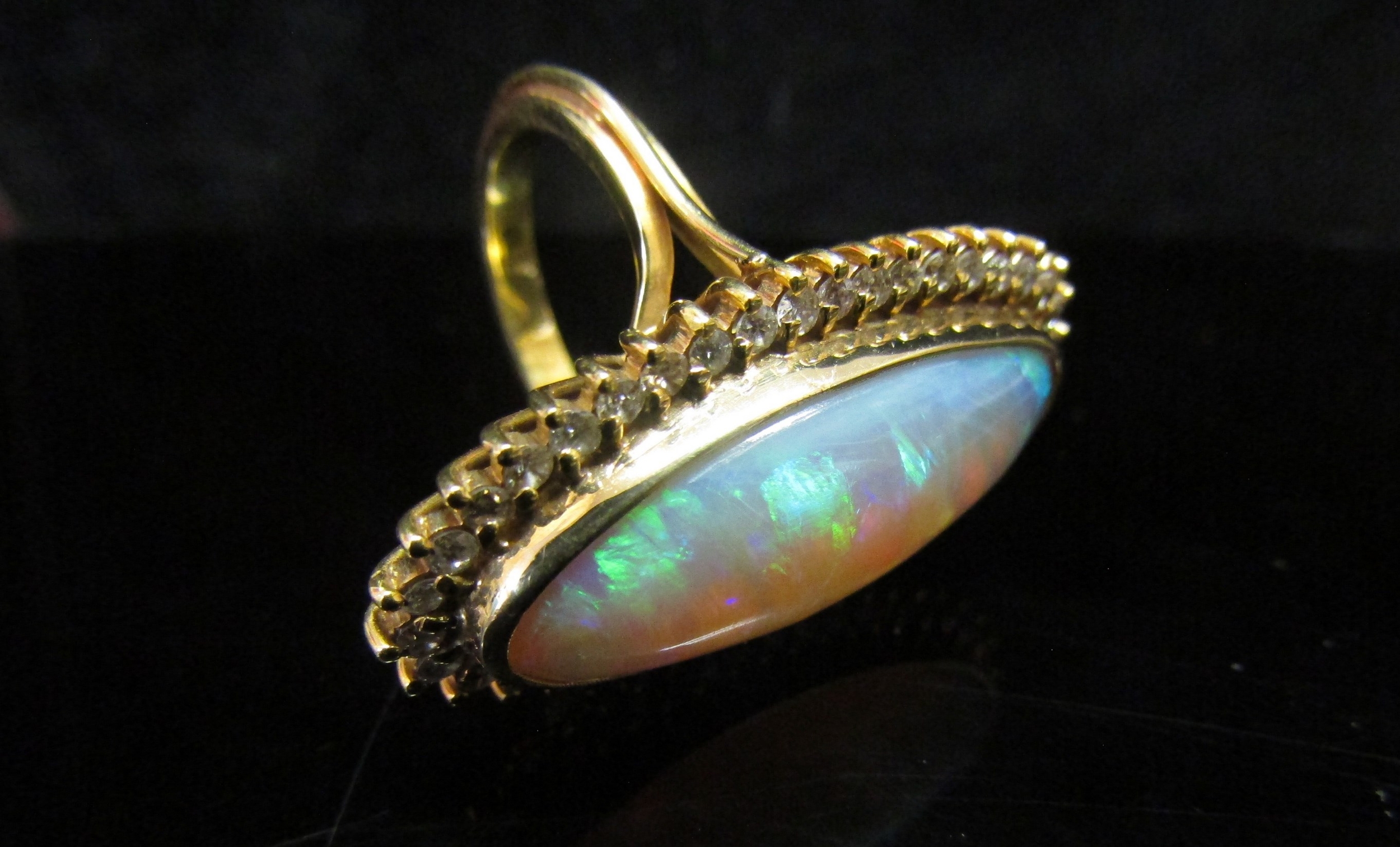 An opal and diamond ring the central oval opal 26.9mm x 10.4mm x 5.4mm, estimated weight 8.87ct