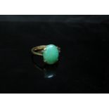 A gold ring set with an oval cabochon jade, stamped 18k. Size O, 3.3g
