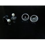 A pair of black enamel and pearl set studs stamped 18ct and a pair platinum studs