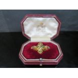 An ornate diamond and emerald gold brooch, unmarked , 4cm x 2.8cm in fitted Garrard and Co box, 9.8g