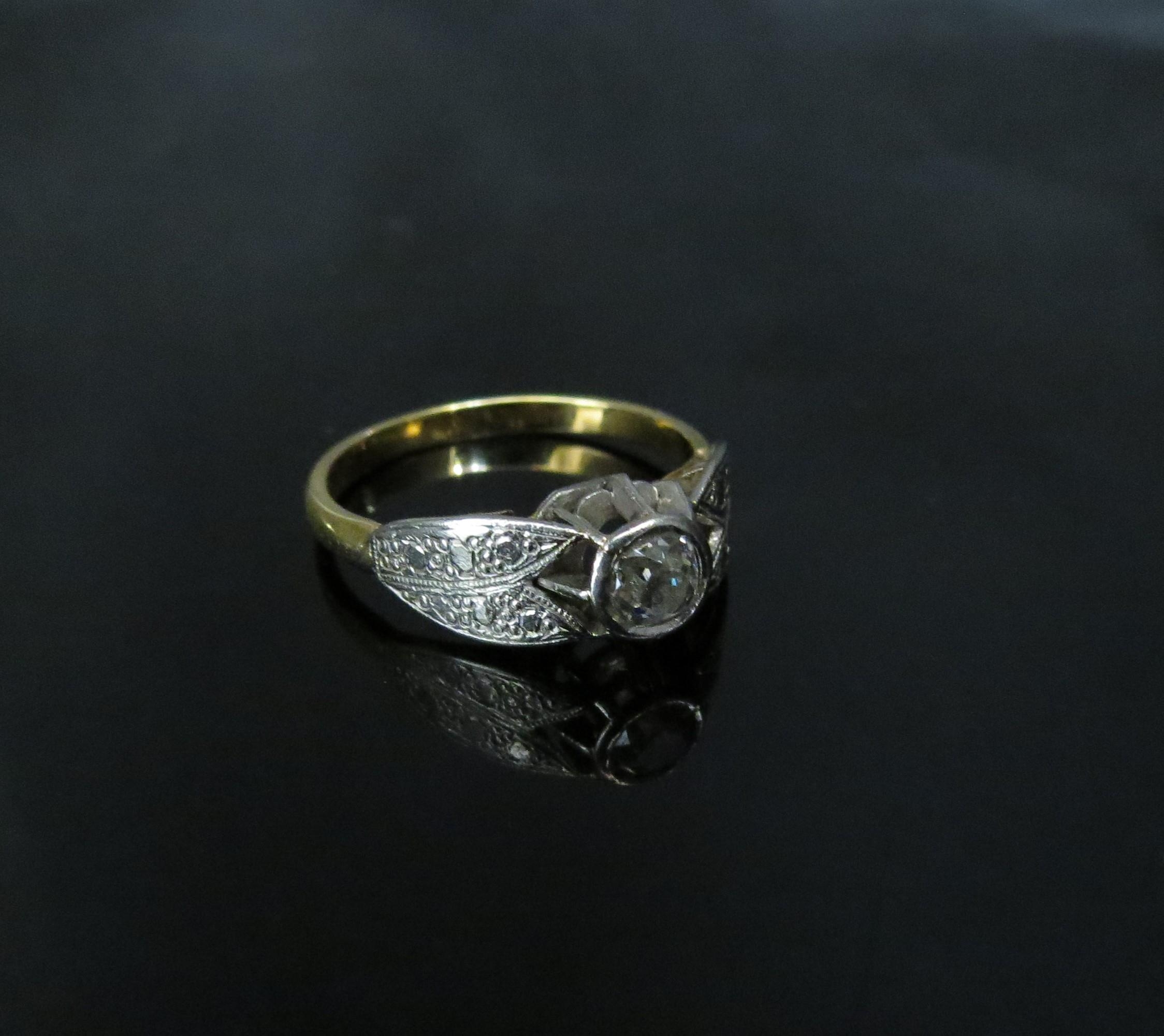 An unmarked gold, platinum set diamond solitaire in rubover setting, 0.20ct approx engraved platinum