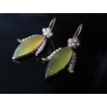 A pair of gold drop earrings set with a yellow cabochon agate with seed pearl flower and leaf