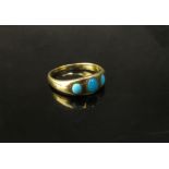 A gold ring with three cabochon turquoise in rubover setting, unmarked. Size O, 3.5g
