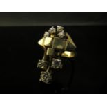 A gold modernistic ring with four small diamonds and block and bar design set with three larger