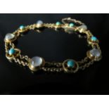 A gold bracelet alternately set with cabochon moonstones and turquoise, double chain links,