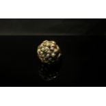 An 18ct gold ring with a domed woven effect basket mount, set with emerald and seed pearls. Size
