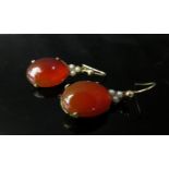 A pair of cornelian cabochons and pearl drop earrings with decorative backs, unmarked, 3cm drop, 5g