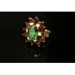 A Cartier dress ring, the centre oval green stone 13mm x 9mm framed by six diamonds and orange/brown