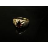 A 9ct gold textured band set with with an oval garnet. Size N/O, 3.1g