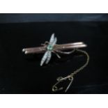 A gold bar brooch with a ruby, peridot and seed pearl set dragonfly, stamped 9ct, 5.5cm long, 4.4g