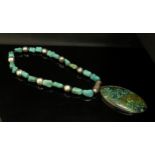 A large turquoise pendant hung on turquoise bead necklace, 46cm long