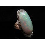 An opal and diamond ring, the central oval cabochon opal 23mm x 12.4mm x 5.77mm, estimated weight