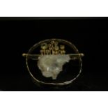 An 18ct gold abstract modernistic brooch of circular form with off centre bar mounted with an