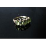 A 9ct gold ring set with five cabochon peridots. Size O/P, 2.7g