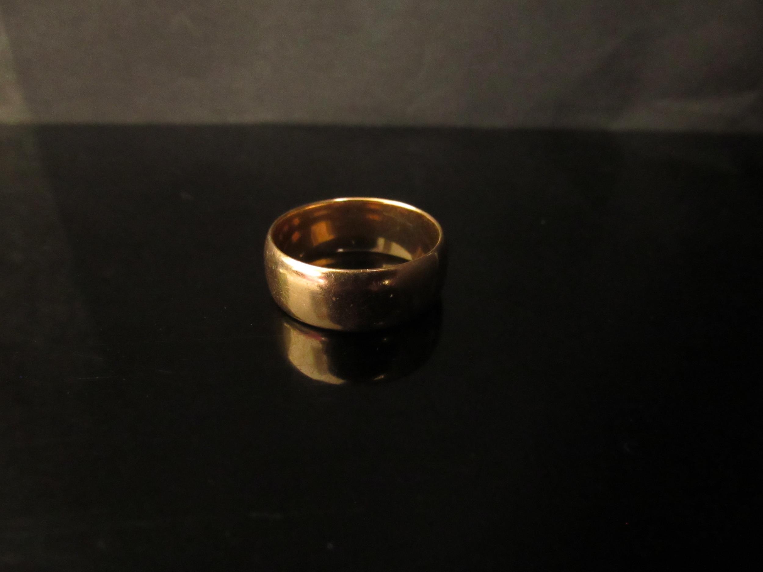 An 18ct gold wedding band, 7mm wide. Size R/S, 8.4g