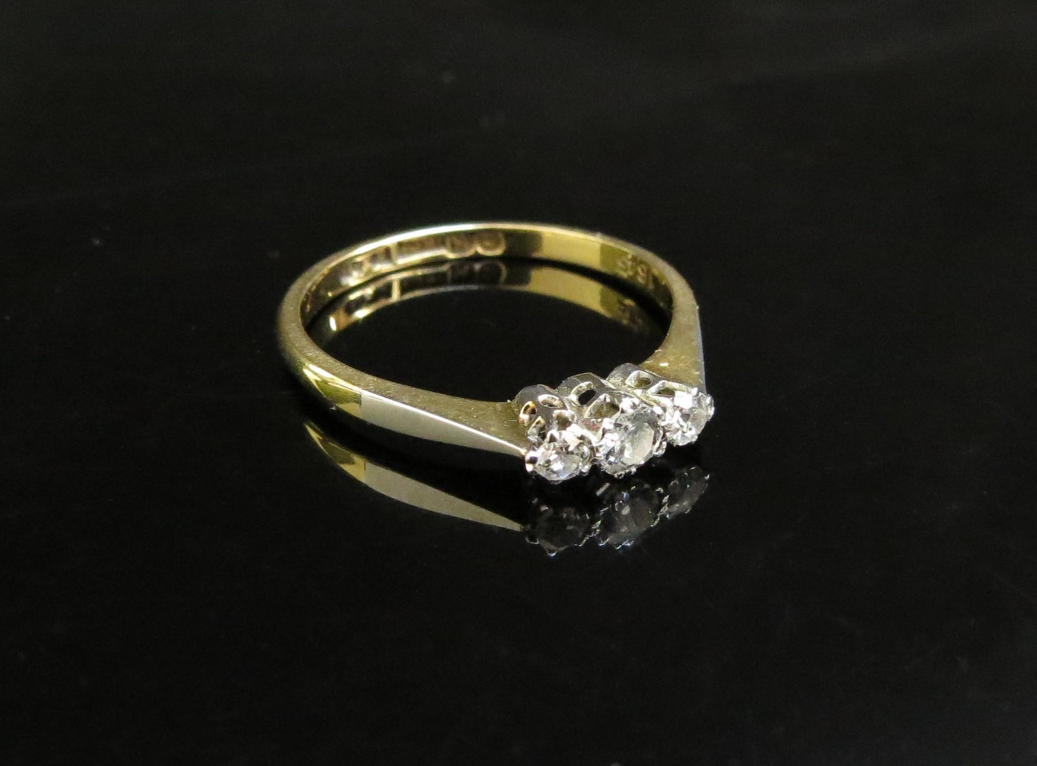 An 18ct gold ring set with three small diamonds. Size M, 2g