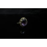 A 9ct gold ring set with an oval amethyst in a fancy mount. Size R, 3.9g