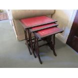 A nest of three leather inset occasional tables with lyre end supports, largest 55cm x 53cm x 37.5cm