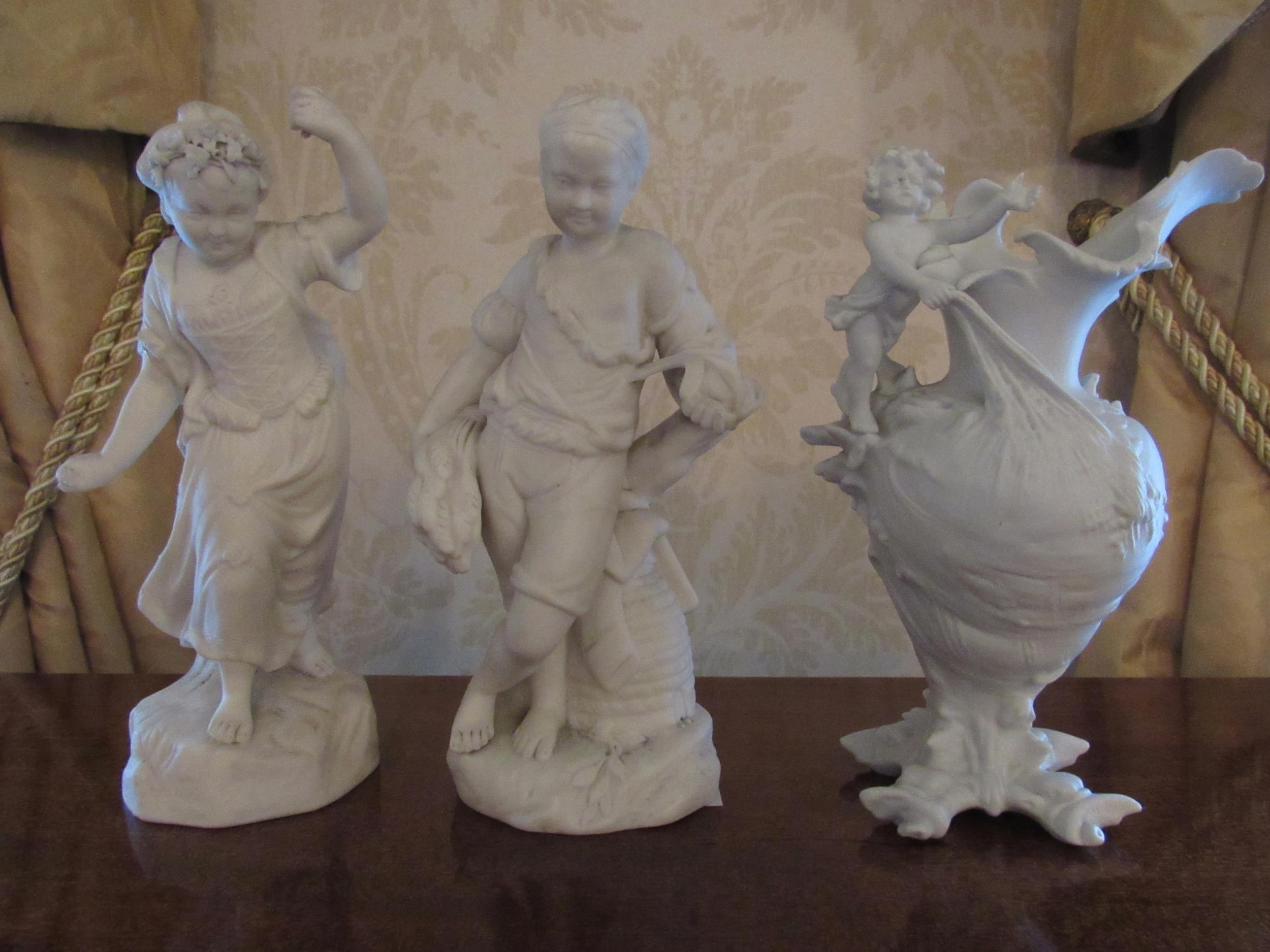 A pair of Parian figures boy and girl, 23.5cm tall and similar vase with cherub (wing a/f) (3)